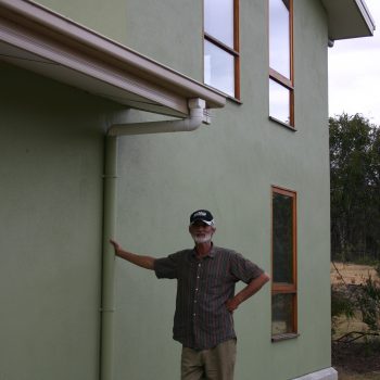Lee Hunter outside his straw panel and internal mud brick wall house.