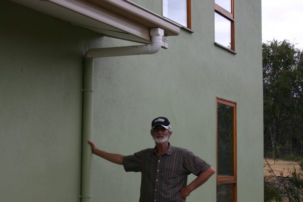 Lee Hunter outside his straw panel and internal mud brick wall house.