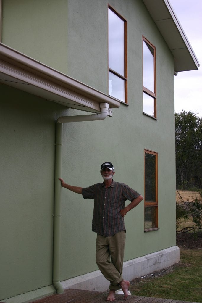Lee Hunter outside his straw panel and internal mud brick wall house.