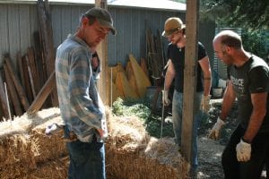 Joel Meadows (right) positions straw bales with help from friends Sid Larwil (left) and Brad Welsh.