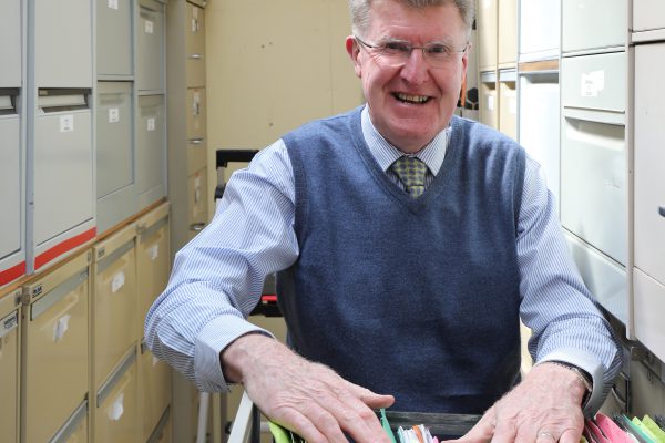 John Keating is shown among some of the thousands of property reports he has compiled on Macedon Ranges property sales.